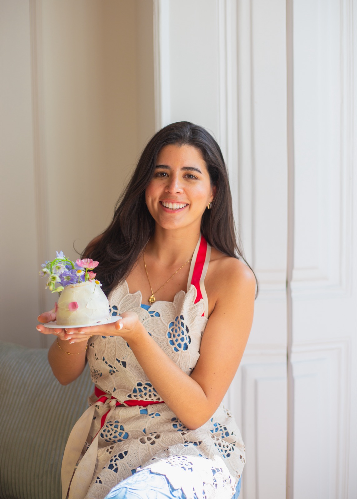 Caro holding a cake decorated with fresh flowers