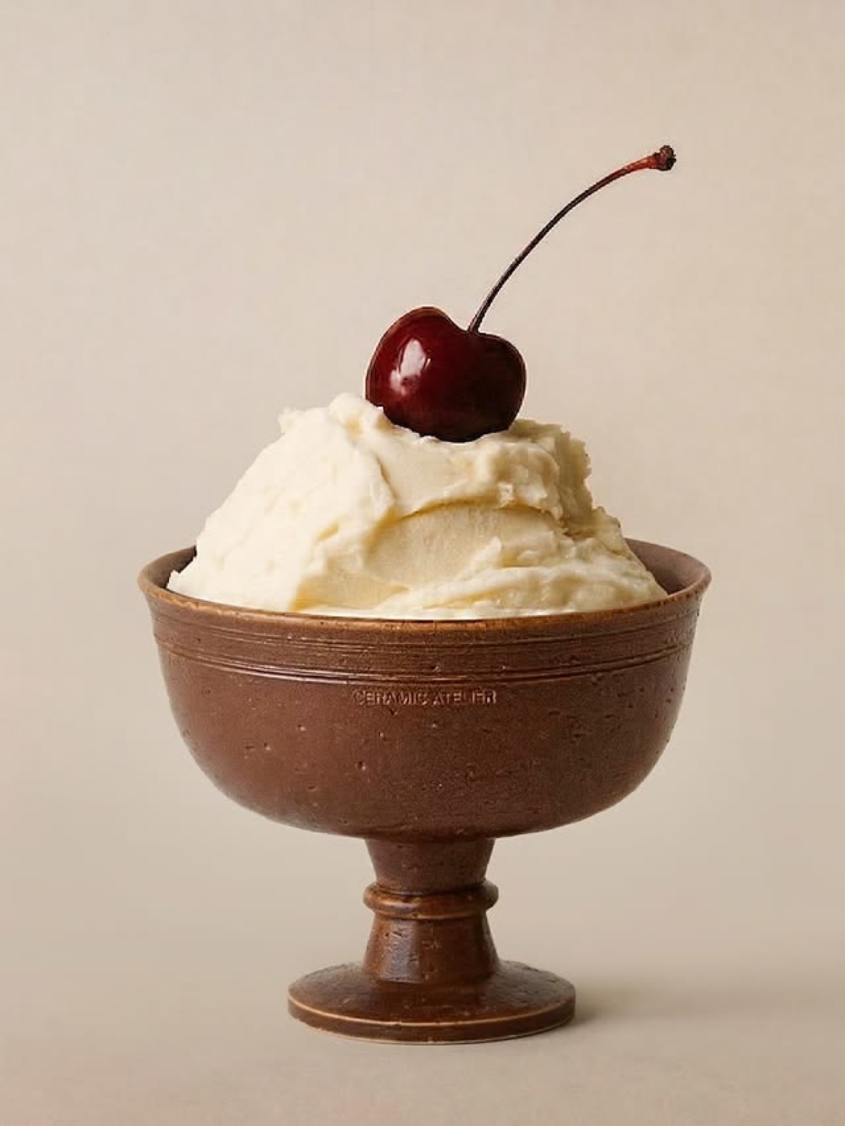 Ice cream with a dark cherry on top